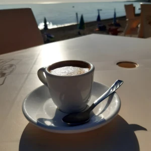Primo piano di un caffe del Bar Maremoto con il mare come sfondo
