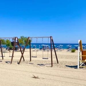 Vista della spiaggia con altalene e scivolo del Villaggio Camping da Mario