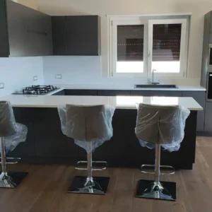 Cucina grigia con piano bianco e penisola con sgabelli da Mobilificio Madera