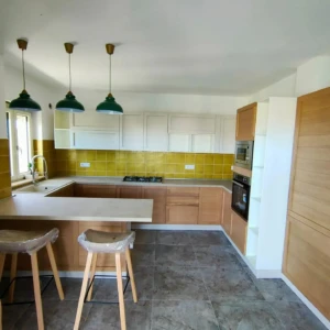 Cucina color legno chiaro, bianco e mattonelle in giallo da Mobilificio Madera