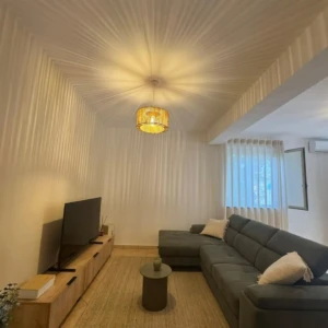 Salotto moderno con divano grigio e mobile tv vista laterale da Mobilificio Madera