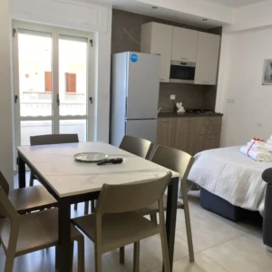 Tavolo e cucina con finestra su esterno di San Giovanni Rooms & Apartments